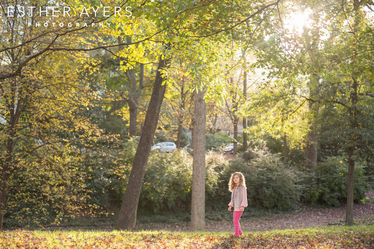 little girl with gorgeous curly hair exploring park at sunset