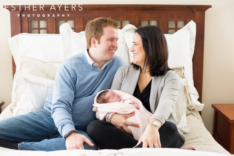 First time parents smiling with newborn baby girl 