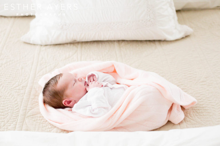 Newborn Baby Girl on Bed wrapped in a pink blanket