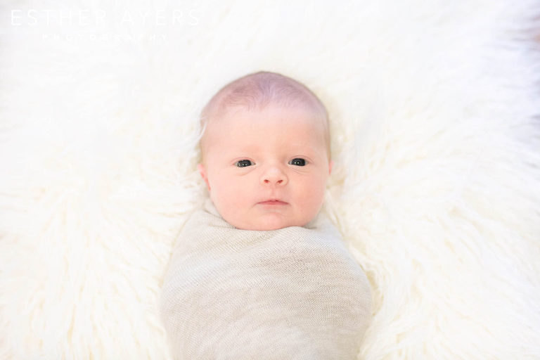 Newborn Baby Girl smiling on faux fur