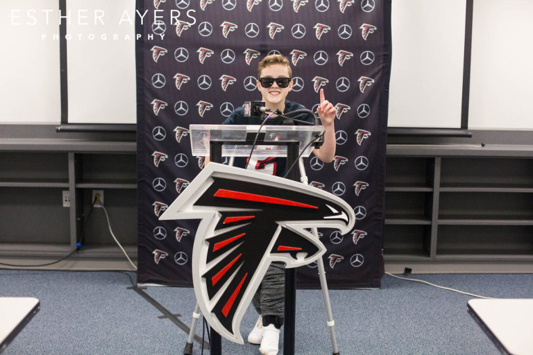Dream on 3 kid with Atlanta Falcons media podium