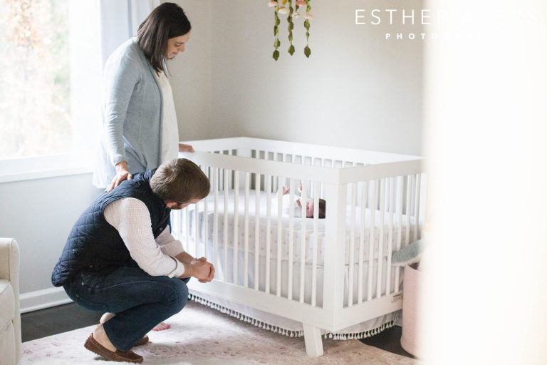 newborn baby girl in nursery and crib with parents