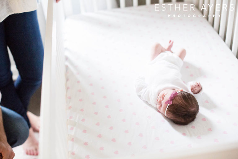 newborn baby girl in nursery and crib with parents
